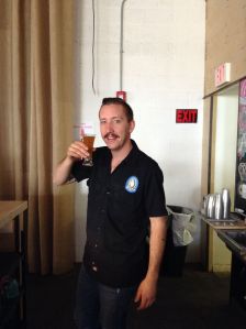 Antal poses with Tractor's special anniversary wheat. It only took Carlos about 10 or 12 tries to get the picture right. (Photo courtesy of Tractor Brewing)