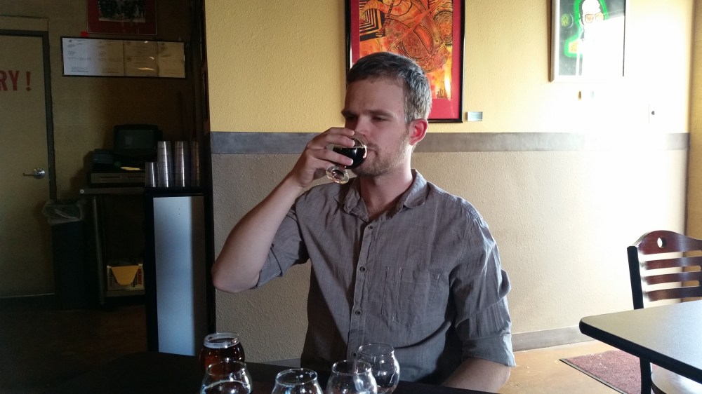 Will Brennand samples the beers at Red Door that they brewed since he left to pursue a masters degree in England.